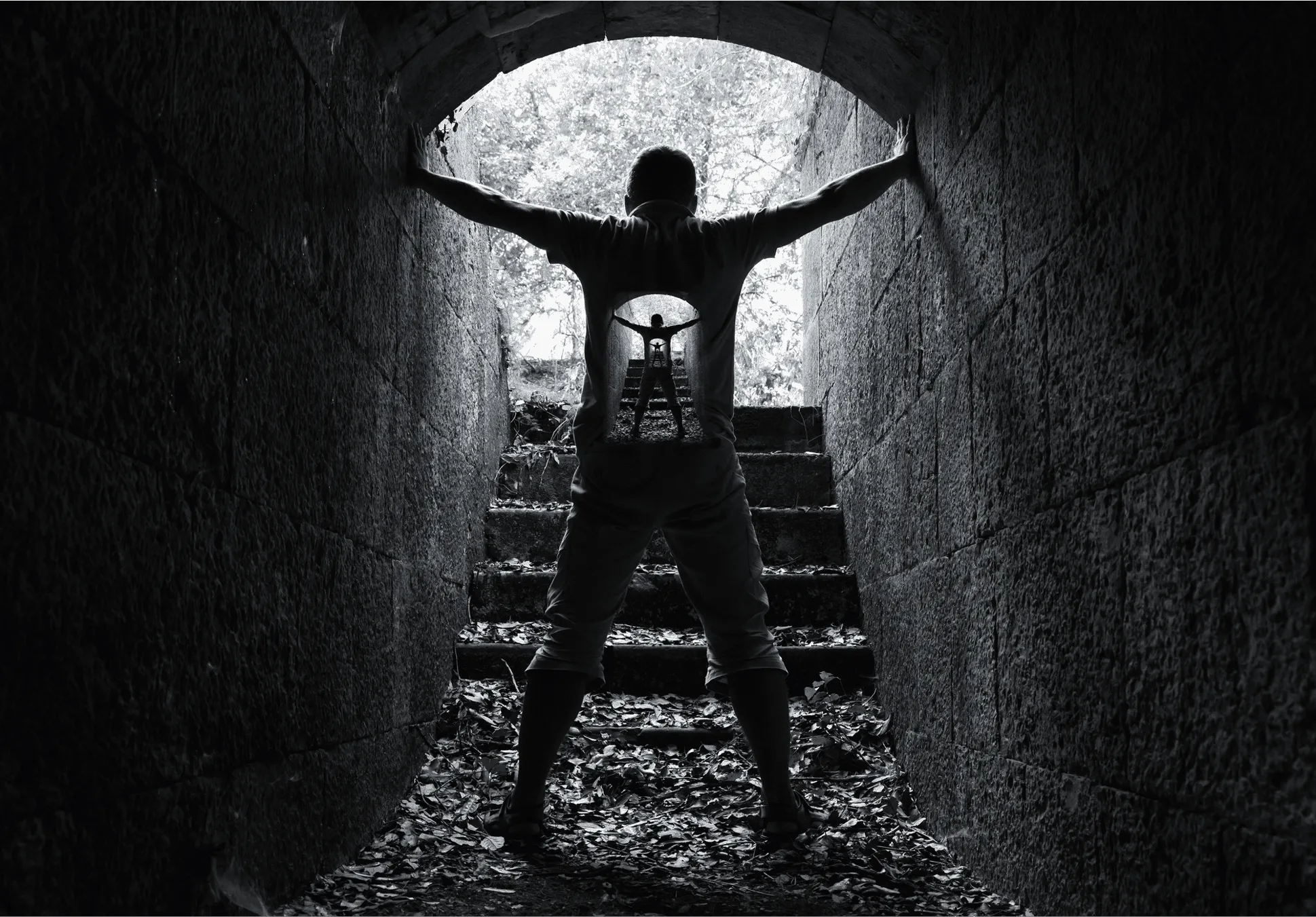 Figure standing at the opening of a tunnel